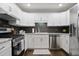 Modern kitchen featuring white cabinets, granite countertops, stainless steel appliances, and dark backsplash at 476 Concord Se Ln, Smyrna, GA 30082