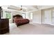 Large bedroom with a tray ceiling, carpet floors, and ample natural light at 6298 Gothards Ln, Douglasville, GA 30134