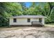 Charming single-story home with a wooden porch and simple landscaping surrounded by mature trees at 114 Howell Sw Dr, Atlanta, GA 30331