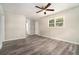 Bright living room featuring sleek wood-look flooring, ceiling fan, and ample natural light through the window at 114 Howell Sw Dr, Atlanta, GA 30331