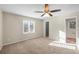 Bright bedroom featuring plush carpeting, a ceiling fan, and natural light from the window at 1403 W Prospect Dr, Lawrenceville, GA 30043
