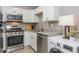Compact kitchen featuring stainless steel appliances, granite counters, and a washer dryer at 2479 Peachtree Ne Rd # 201, Atlanta, GA 30305
