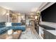 Open-concept living space with a blue sofa, modern entertainment unit, and view into the dining area at 2479 Peachtree Ne Rd # 201, Atlanta, GA 30305