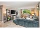 Bright living room featuring a plush blue sofa, modern shelving, and large windows with a lush green view at 2479 Peachtree Ne Rd # 201, Atlanta, GA 30305