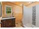 Cozy bathroom with wood paneling, stand-up shower with tile accents and wood-framed window at 639 Hall Station Rd, Kingston, GA 30145