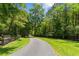 Long driveway winding through a lush green lawn and mature trees at 639 Hall Station Rd, Kingston, GA 30145