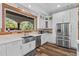 Modern kitchen showcasing stainless steel appliances, white cabinets, quartz countertops, and a view to the outside at 639 Hall Station Rd, Kingston, GA 30145