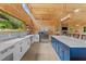 Open kitchen with island, stainless steel appliances, modern countertops, and stylish blue cabinets at 639 Hall Station Rd, Kingston, GA 30145