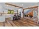 Bright kitchen with white cabinets, a center island, and hardwood floors leading to a staircase at 639 Hall Station Rd, Kingston, GA 30145