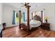 Elegant bedroom with a four-poster bed, hardwood floors, and natural light from the large windows at 639 Hall Station Rd, Kingston, GA 30145