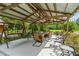 Covered outdoor seating area with swing, dining table, and manicured backyard at 639 Hall Station Rd, Kingston, GA 30145