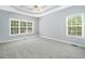 Spacious bedroom featuring tray ceilings, neutral paint, large windows and neutral carpeting at 9996 Village South Dr, Douglasville, GA 30135