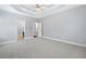 Large bedroom features neutral carpeting, a tray ceiling and white trim throughout at 9996 Village South Dr, Douglasville, GA 30135