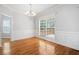 Formal dining room with hardwood floors, wainscoting, chandelier, and large window at 9996 Village South Dr, Douglasville, GA 30135