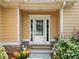 Close-up of a front door with glass panels, surrounded by vibrant landscaping and stone accents at 9996 Village South Dr, Douglasville, GA 30135