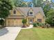 Charming home exterior with a manicured lawn, stone details, and a convenient two-car garage at 9996 Village South Dr, Douglasville, GA 30135