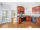 Kitchen features stainless steel appliances, wood cabinets, hardwood floors and door to exterior deck at 9996 Village South Dr, Douglasville, GA 30135
