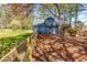 View of the backyard featuring the house, a wooden fence, and natural landscaping at 216 Hickory Way, Canton, GA 30115