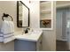 Stylish bathroom featuring a gray vanity, modern fixtures, and decorative shelving with flowers at 216 Hickory Way, Canton, GA 30115