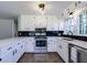 Well-lit kitchen with white cabinets, black hardware, stainless steel appliances, and modern countertops at 216 Hickory Way, Canton, GA 30115