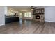 Open-concept living area featuring a stone fireplace, vinyl floors, and views of the kitchen at 216 Hickory Way, Canton, GA 30115