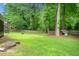 Large grassy backyard is fenced in, featuring mature trees and plenty of room to play at 3123 Westbrook Trce, Lawrenceville, GA 30044