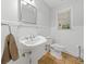 Elegant half bathroom featuring classic pedestal sink and decorative mirror at 3123 Westbrook Trce, Lawrenceville, GA 30044
