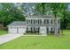 Traditional two-story home with a well-kept lawn, mature tree, and a two-car garage at 3123 Westbrook Trce, Lawrenceville, GA 30044