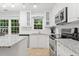 Bright kitchen featuring white cabinets, granite countertops, and stainless steel appliances at 3123 Westbrook Trce, Lawrenceville, GA 30044