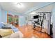 Living room features a fireplace, wood floors, a sofa, and an exercise machine at 3123 Westbrook Trce, Lawrenceville, GA 30044