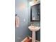 Charming bathroom features a pedestal sink, a framed mirror, and blue-painted walls at 3439 Tupelo Trail, Auburn, GA 30011