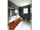 Bathroom with a wood vanity, white tile floors, and shower/tub combo at 3439 Tupelo Trail, Auburn, GA 30011