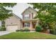 Charming two-story home featuring a brick facade, red shutters, a manicured lawn, and an attached two-car garage at 3439 Tupelo Trail, Auburn, GA 30011
