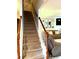Carpeted staircase with wood banister leads to a cozy living room with neutral decor at 3439 Tupelo Trail, Auburn, GA 30011