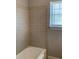 Bathroom with tiled shower, white tub, and a window letting in natural light at 2367 Cascade Rd # B7, Atlanta, GA 30311