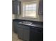 Kitchen with black appliances, gray cabinets, and a stainless steel sink under the window at 2367 Cascade Rd # B7, Atlanta, GA 30311