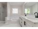 Bright bathroom showcasing a soaking tub, separate shower, and double vanity with modern fixtures and marble floors at 4252 Keheley Lake Dr, Marietta, GA 30066