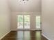 Sunlit living room featuring hardwood floors, large windows, and access to outdoor deck at 4252 Keheley Lake Dr, Marietta, GA 30066
