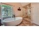 Bright bathroom featuring a soaking tub, walk-in shower, and lots of natural light at 3314 Eagle Watch Dr, Woodstock, GA 30189