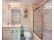 Well-lit bathroom with a vanity, toilet, and tiled shower with gold trim at 3314 Eagle Watch Dr, Woodstock, GA 30189