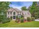 Elegant two-story home with a manicured lawn, mature trees, and a welcoming double door entrance at 3314 Eagle Watch Dr, Woodstock, GA 30189