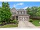 Charming two-story home with a well-manicured lawn, a two-car garage, and lovely landscaping, with gray paint and stone accents at 5901 Cobblestone Creek Cir, Mableton, GA 30126