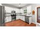 Well-lit kitchen featuring white cabinets and stainless steel appliances at 5901 Cobblestone Creek Cir, Mableton, GA 30126