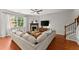 Bright living room featuring a fireplace, a large sectional sofa, hardwood floors, and a ceiling fan at 5901 Cobblestone Creek Cir, Mableton, GA 30126