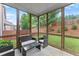 Cozy screened porch with seating, offering a view of the backyard and landscaping at 5901 Cobblestone Creek Cir, Mableton, GA 30126
