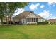 Backyard patio with seating and well-maintained lawn surrounded by mature trees at 9634 Coastal Pointe Dr, Villa Rica, GA 30180
