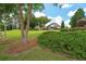 Well-manicured backyard with lush greenery, view of home, shrubs and mature trees at 9634 Coastal Pointe Dr, Villa Rica, GA 30180