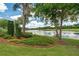 Lush backyard with view of a pond and landscaped with trees and mulch at 9634 Coastal Pointe Dr, Villa Rica, GA 30180