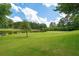 Expansive backyard leading to a serene pond with a backdrop of lush golf course greens at 9634 Coastal Pointe Dr, Villa Rica, GA 30180