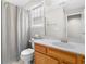 Cozy bathroom features a wood vanity, and shower with curtain and window at 9634 Coastal Pointe Dr, Villa Rica, GA 30180